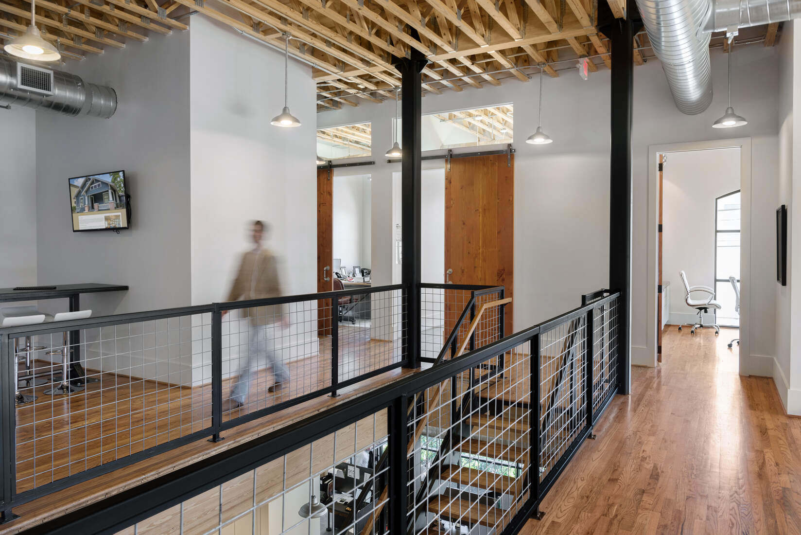Interior of a commercial renovation project by GSD Construction in Houston, TX, with exposed wood beams and modern railings