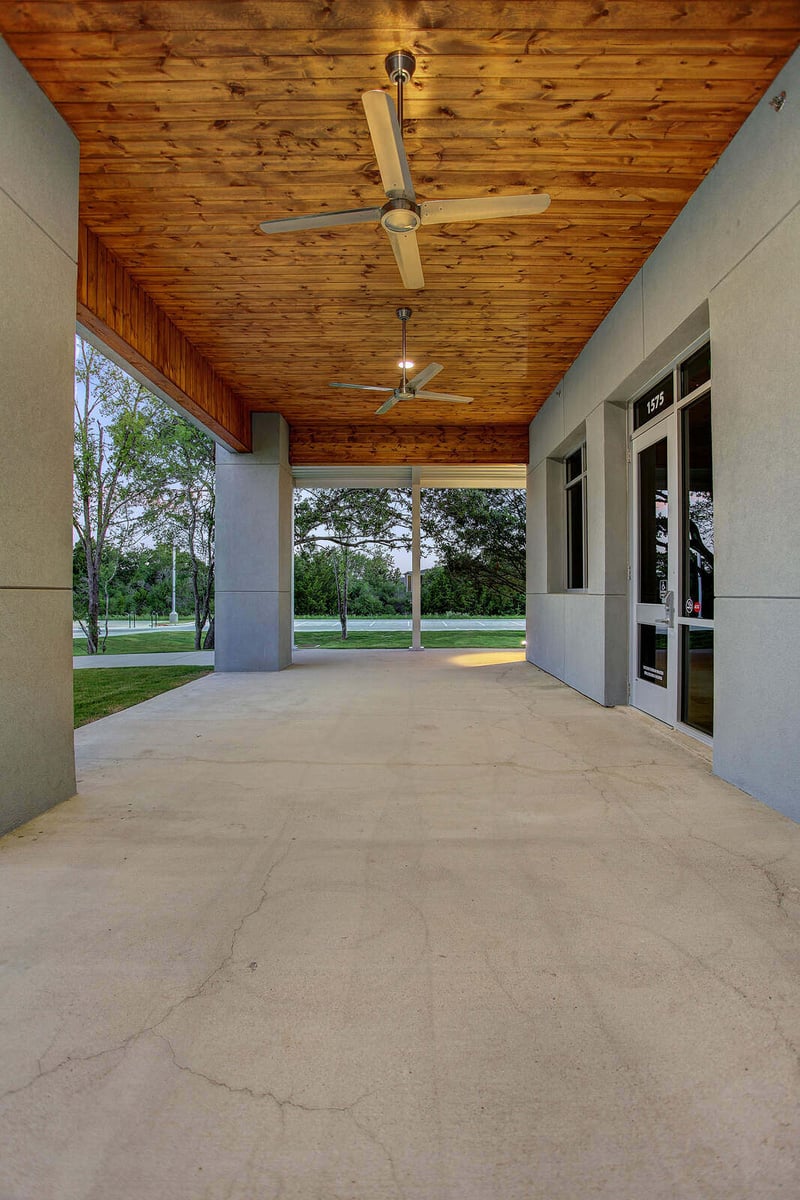 Brightly illuminated exterior corridor leading to a commercial building by GSD Construction in Houston, TX