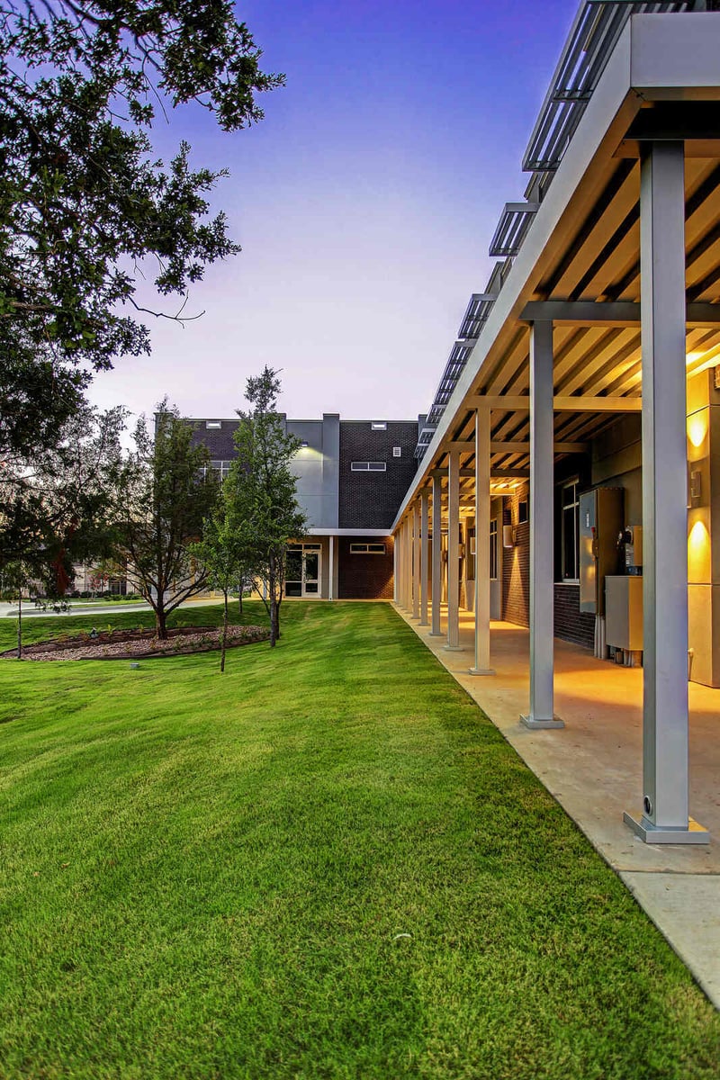 Side lawn with a modern covered walkway at a commercial property renovated by GSD Construction in Houston, TX